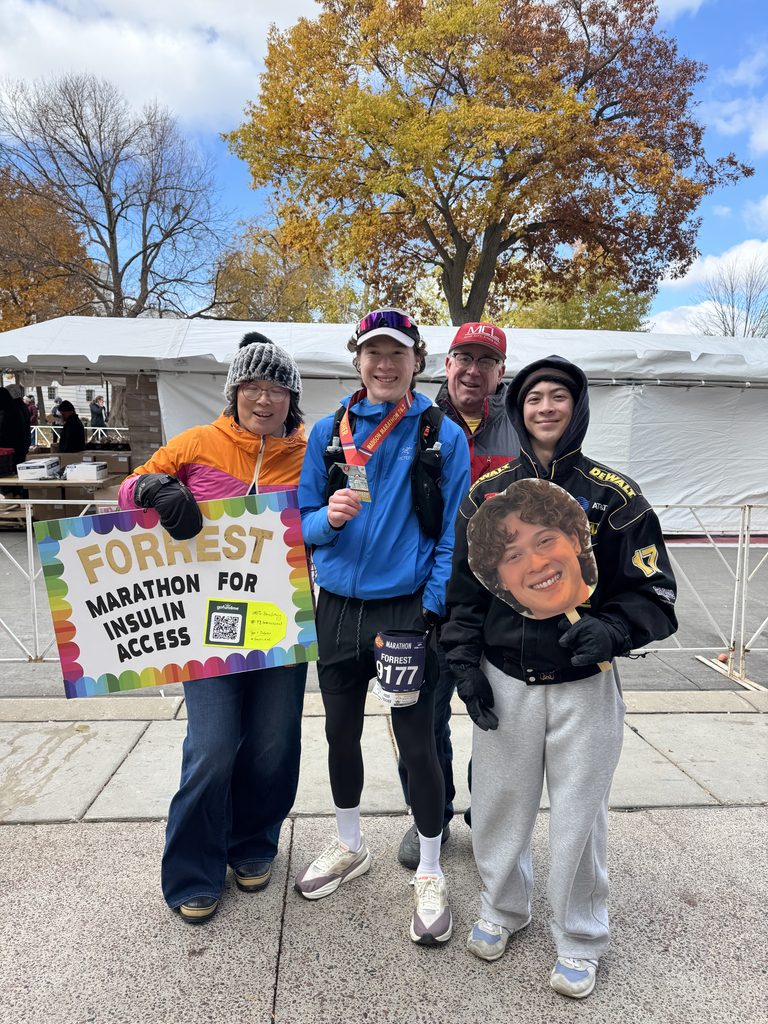 Forrest and family pose after race with signs