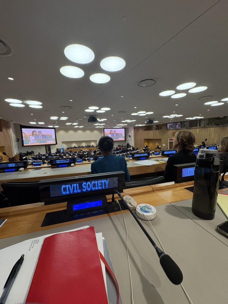 Shaina at UN - back of heads - civil society sign