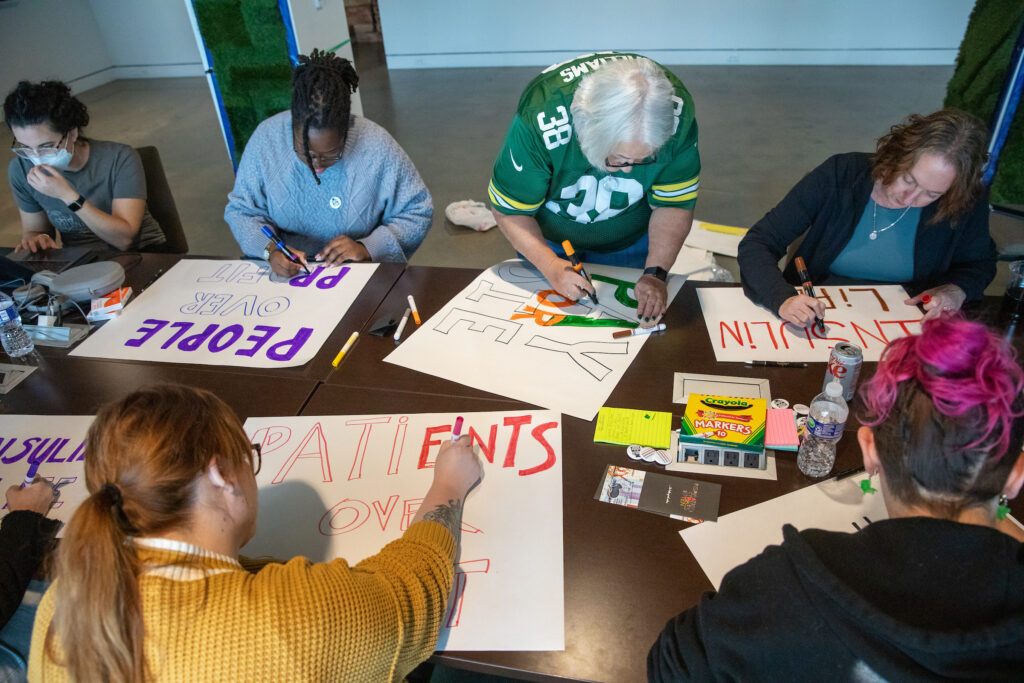 People making posters on a table preparing for a rally