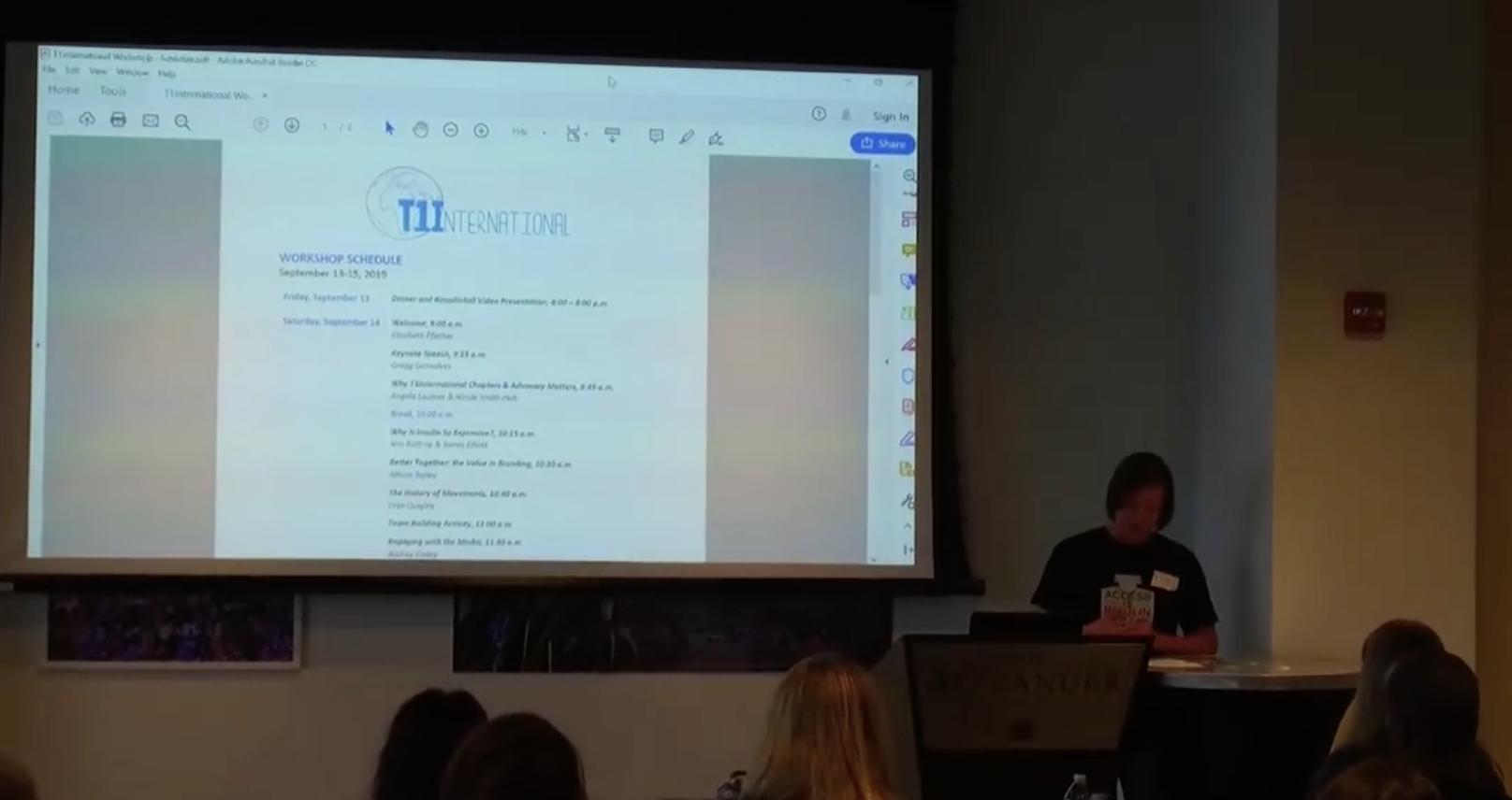 screenshot from the workshop video featuring Nicole at a podium with a screen behind her