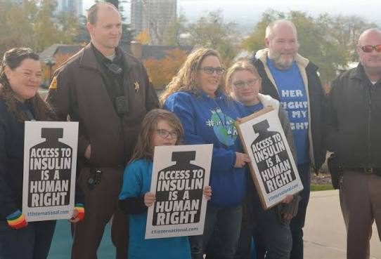 Advocates outdoors holding “Access to insulin is a human right” placards