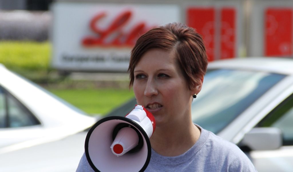 Angela outside Eli Lilly speaking into a megaphone