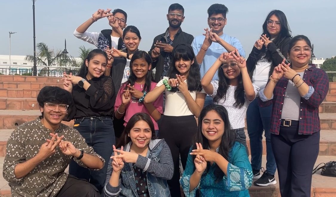 A group of people making hashtags with their hands and smiling at the camera for the India Day of Action 2024