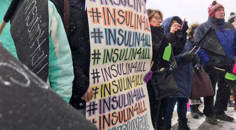 advocates hold signs outside the Minnesota state house during a rally for affordable insulin