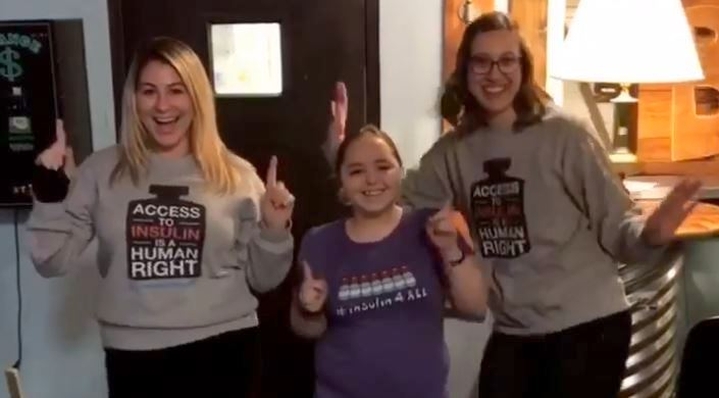 Three ladies stand with their 'access to insulin is a human right' t-shirts on, looking happy