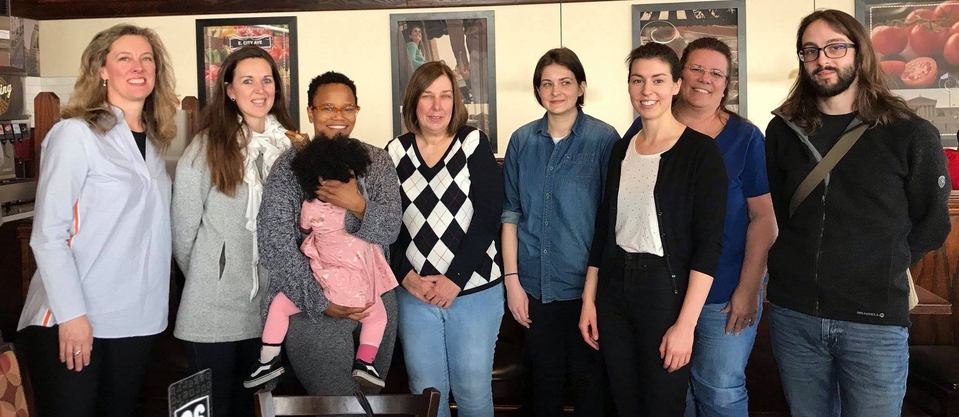 Eight Chapter members stand together at one of the group meetings